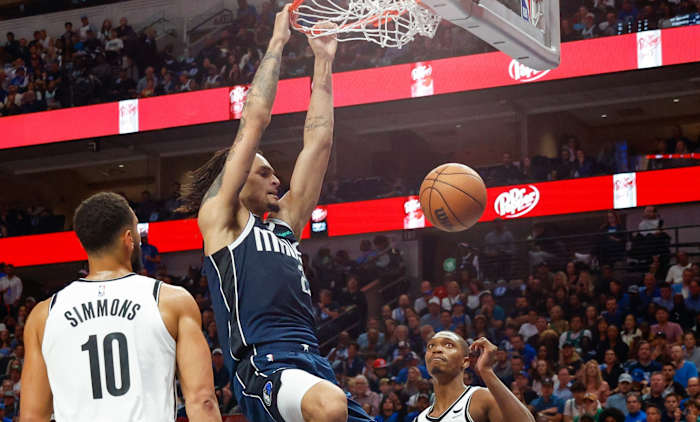 Dereck Lively II slams home a dunk as Ben Simmons and Lonnie Walker IV look on.